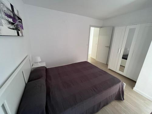 a bedroom with a large bed in a white room at Ático puerto Burriana in Burriana