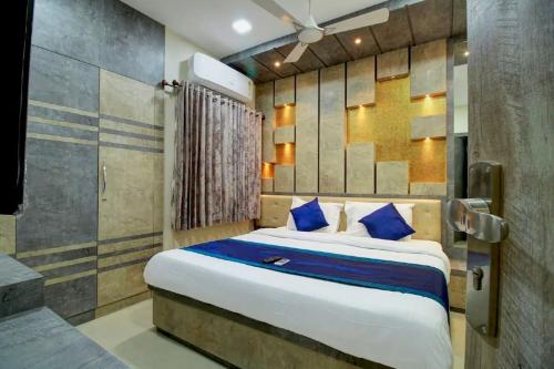 a bedroom with a large bed with blue pillows at SR BOUTIQUE STAY SERVICE APARTMENT in Coimbatore