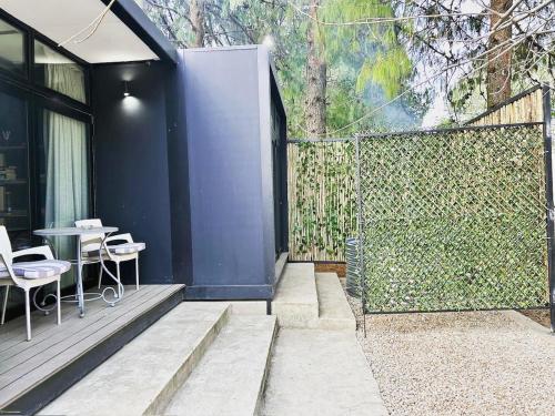 a patio with a fence and a table and chairs at TWO Prefab Living - Luxury bungalows in Dullstroom