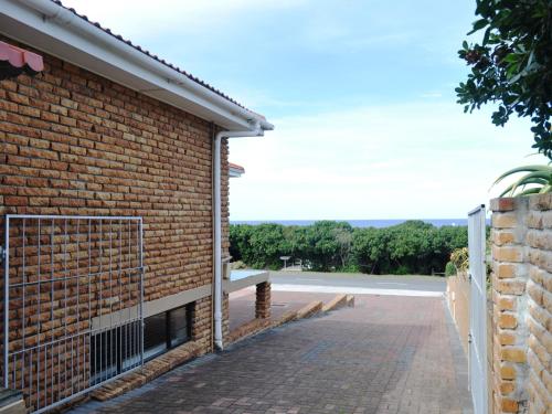 a brick wall with a gate on the side of a building at Great White Accommodation in Kleinbaai