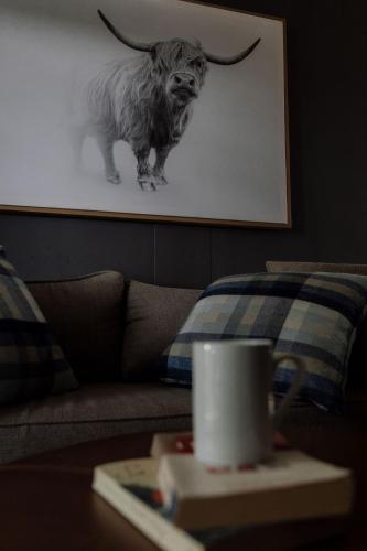 a living room with a couch with a picture of a bull at TWO Prefab Living - Luxury bungalows in Dullstroom