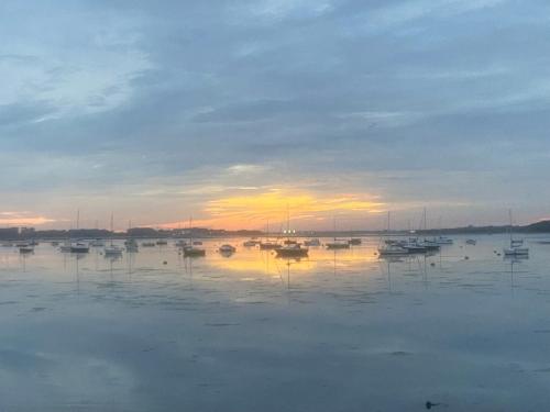 a group of boats sitting in the water at sunset at Kip 23 JJs Emsworth in Emsworth