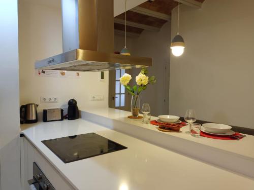 eine Küche mit einer Arbeitsplatte mit Blumen und Gläsern in der Unterkunft Private rooms in Gothic in Barcelona