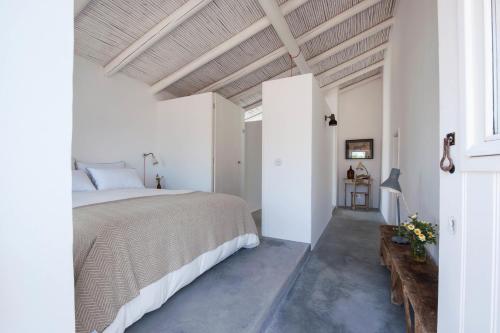 a bedroom with a large bed in a white room at Pensão Agrícola in Tavira