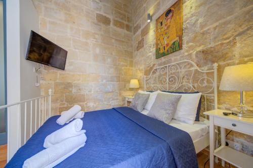 a bedroom with a blue bed with towels on it at Valletta Waterfront Villa with Pool and Jacuzzi in Valletta