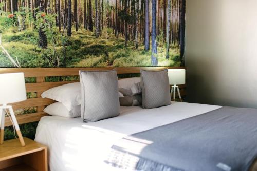 a bedroom with a bed with a painting on the wall at Agapé Boutique Guesthouse Bothaville in Bothaville