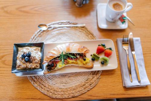 a plate with a sandwich and fruit on a table at Agapé Boutique Guesthouse Bothaville in Bothaville