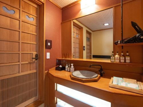 a bathroom with a sink and a mirror at 18歳以上の宿 澄江知多 in Utsumi