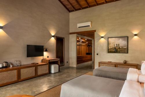 a bedroom with a bed and a flat screen tv at Villa Thamburu, Bentota in Bentota