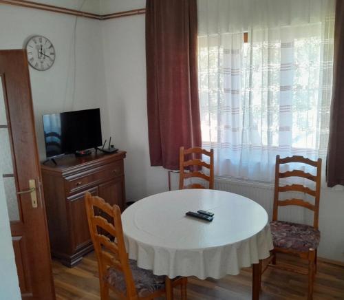 a dining room with a table and chairs and a clock at Guest house Kolasin in Kolašin