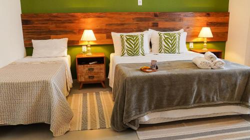 1 dormitorio con 2 camas y pared verde en Pouso da Rita - Tiradentes, en Tiradentes