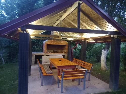 a wooden picnic table and benches under a pavilion at Peaceful Oasis - house for rest and relaxation in Bosanska Krupa