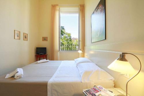 1 dormitorio con 1 cama con lámpara y ventana en Relais White Houses Florence, en Florencia