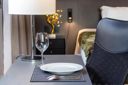 a table with a plate and a lamp and a glass at Flat 1111 WCT Berrini Brooklin in Sao Paulo