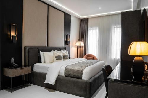 ポートハーコートにあるDLUXE PREMIUM HOTELのベッドとテーブルが備わるホテルルームです。
