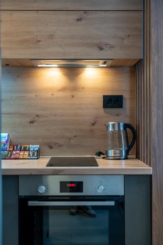 a kitchen with a stove with a pot on top of it at King's Square Lux apartment Zlatibor 1 in Zlatibor