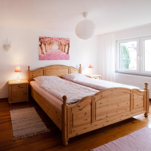 a bedroom with a wooden bed and two night stands at 4 Bett Ferienwohnung Lavendel in Wengenroth