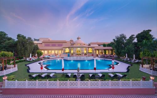 an exterior view of a mansion with a swimming pool at Heritage Village Resort & Spa Manesar-Gurgaon in Gurgaon