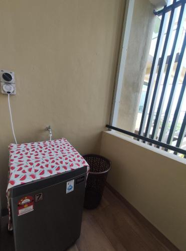 a room with a trunk in front of a window at Senandika Homestay in Kuching