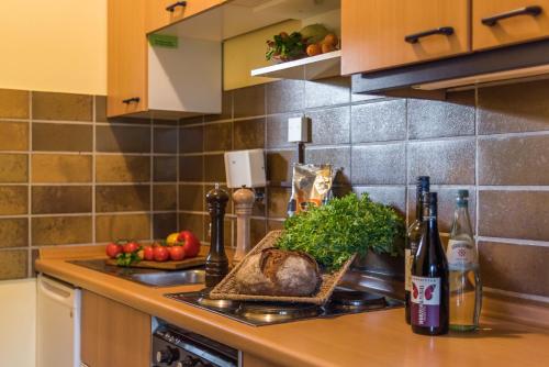 a kitchen with a counter with food and wine bottles at Sporthotel Grafenwald 4 Sterne Superior in Daun