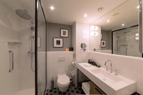 a bathroom with a toilet and a sink and a shower at Canopy by Hilton Zagreb City Centre in Zagreb