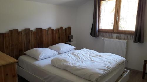 a bed with two pillows on it in a bedroom at Les Balcons de L'Izoard - L'écureuil in Arvieux