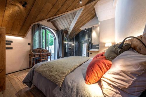 sypialnia z łóżkiem w pokoju z drewnianym sufitem w obiekcie La Grange aux Hirondelles -5 étoiles- Saint-Malo w Saint-Malo
