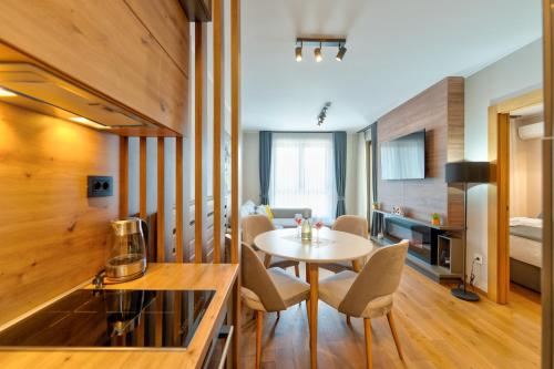 a room with a table and chairs and a bedroom at King's Square Lux apartment Zlatibor 1 in Zlatibor