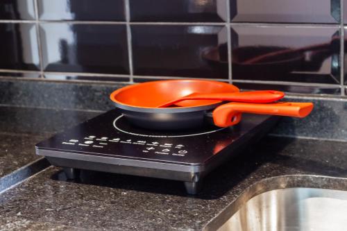 an orange bowl and utensils sitting on top of a kitchen counter at Flat 1111 WCT Berrini Brooklin in Sao Paulo