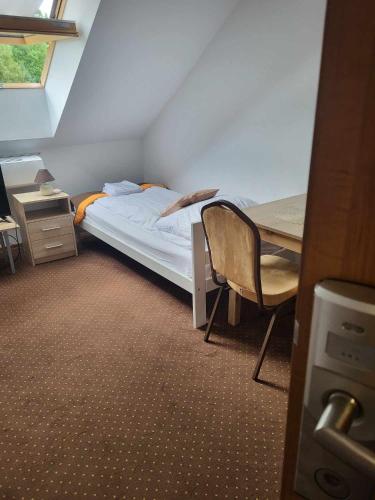 ein kleines Schlafzimmer mit einem Bett und einem Schreibtisch in der Unterkunft Zajazd Promyk 