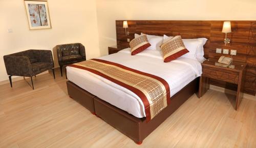 a bedroom with a bed with a desk and a chair at Lacosta Hotel in Aqaba