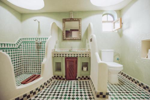 bagno con servizi igienici, lavandino e specchio di Traditional Riad Merzouga Dunes a Merzouga