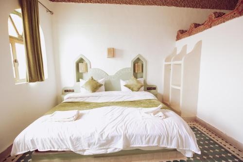 Postel nebo postele na pokoji v ubytování Traditional Riad Merzouga Dunes