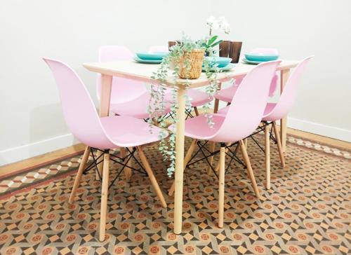 a dining room with pink chairs and a table at By Plaza Catalunya Rooms in Barcelona