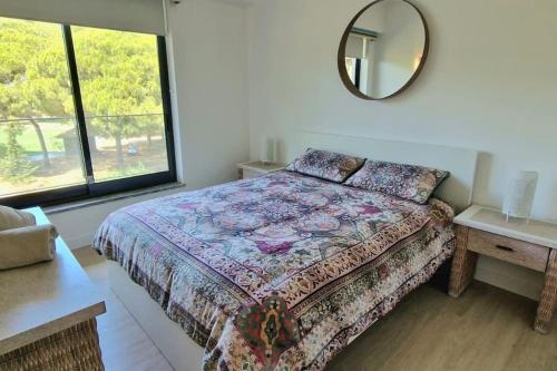 1 dormitorio con cama y espejo en la pared en Spacious Residence Golf apartment - Vilamoura en Quarteira