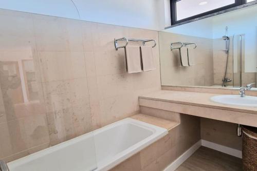 y baño con bañera y lavamanos. en Spacious Residence Golf apartment - Vilamoura en Quarteira