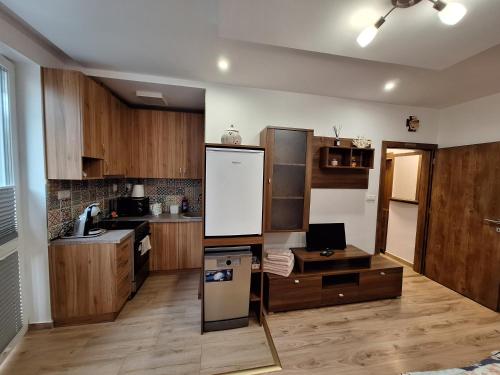 a kitchen with wooden cabinets and a white refrigerator at Diana Apartments 2 in Bardejov