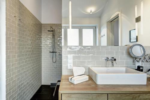 a bathroom with a white sink and a mirror at Gorki Apartments in Berlin