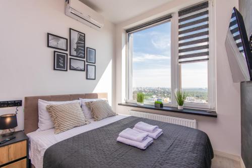 Un dormitorio con una cama grande con toallas moradas. en MYFREEDOM Видові Апартаменти ВДНГ, en Kiev