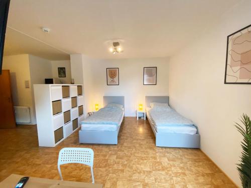 Cette chambre comprend 2 lits et une table. dans l'établissement Cozy Apartment in Oberhausen, à Oberhausen