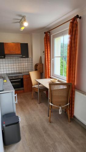 a kitchen with a table and chairs and a window at Haus Schönblick in Simmerath