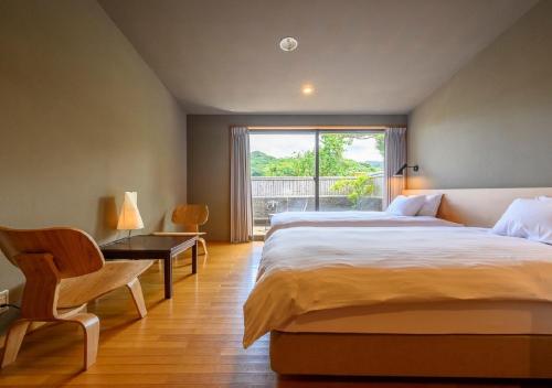 a bedroom with a bed and a desk and a window at Kawatana Grand Hotel Otafuku in Shimonoseki
