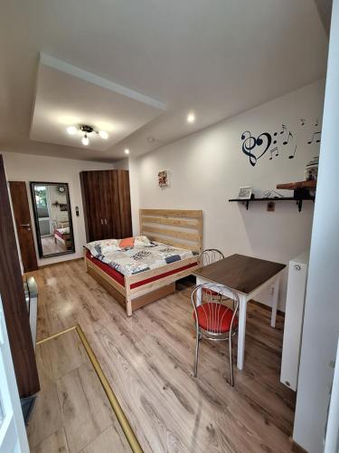 a bedroom with a bed and a table and a desk at Diana Apartments 2 in Bardejov