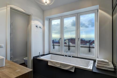 a bathroom with a large tub with a large window at Gorki Apartments in Berlin