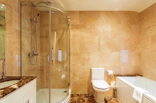 a bathroom with a shower and a toilet and a sink at The Falcon Hotel in Uppingham