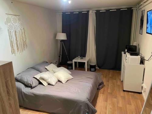 Un dormitorio con una cama con almohadas. en Studio Lac d'Enghien en Enghien-les-Bains