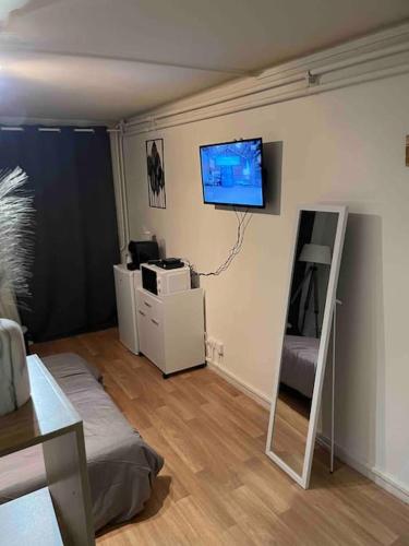 sala de estar con TV de pantalla plana en la pared en Studio Lac d'Enghien en Enghien-les-Bains