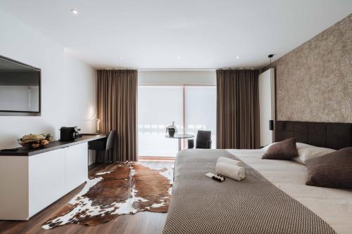 ein Hotelzimmer mit einem großen Bett und einem Schreibtisch in der Unterkunft Cosmopolite Hotel Nieuwpoort-Bad in Nieuwpoort