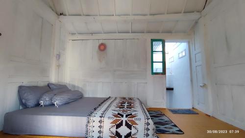 ein Zimmer mit einem Bett in einem weißen Raum in der Unterkunft Omah Kayu Palagan in Ngaglik
