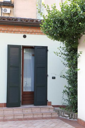 a door with black shutters on a white building at Abbazia Bed & Breakfast, MantegnaHotels in Mantova